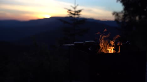 summer barbecue. flames heating up grill. sunset