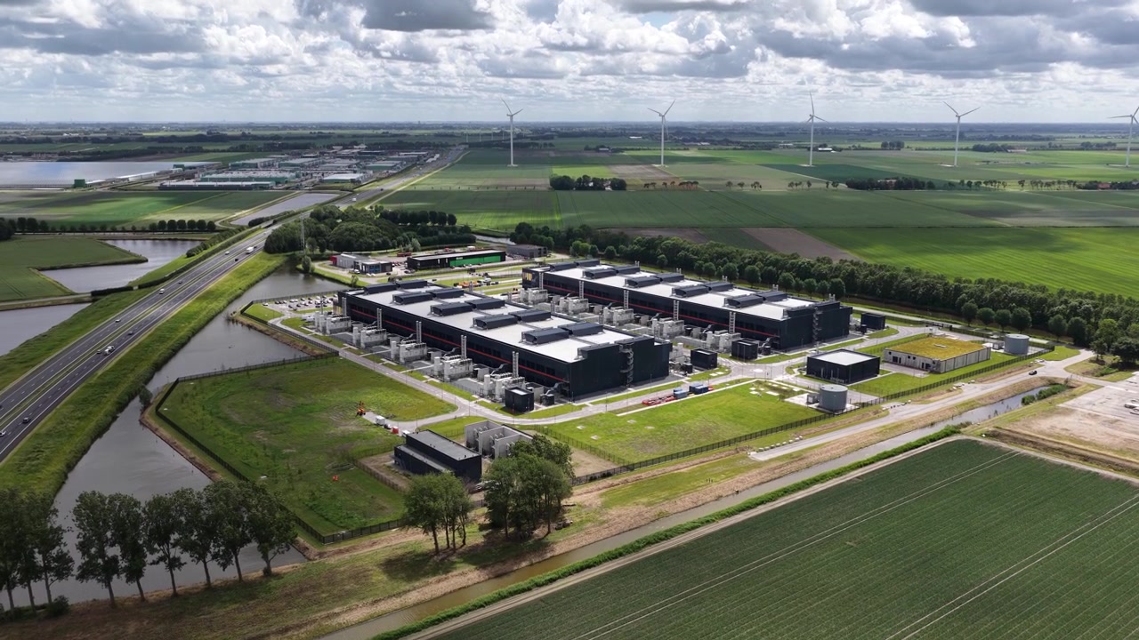 Luftfoto af en stor datacenter-tårnbygning, der viser cloud computing-infrastruktur, digital lagring, sikre serverfaciliteter og moderne IT-drift