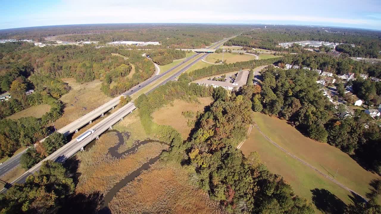 vista de una interestatal activa con coches y camiones cruzando una sección de puente sobre un pantano de agua salada