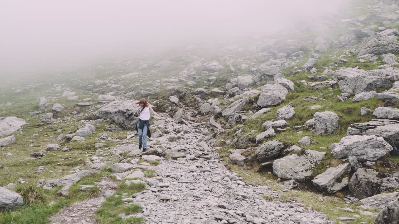 молодая туристка поднимается на горы с фотокамерой. трансагарасан, карпатские горы в румынии