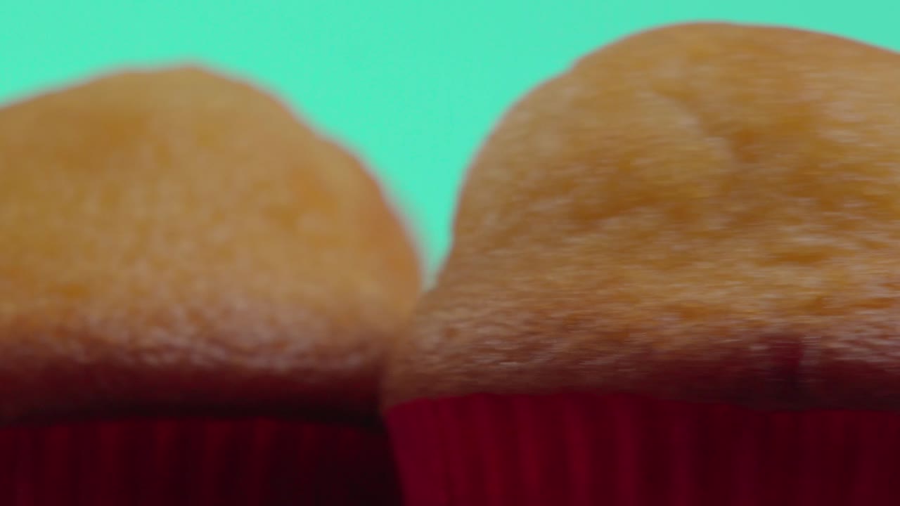 초록색 배경에 회전하는 머핀이나 타말레스 컵케이크의 클로즈업.