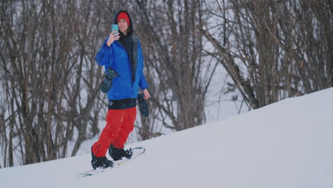 usa tu teléfono inteligente para tomar fotografías de paisajes mientras haces snowboard en la pista de esquí