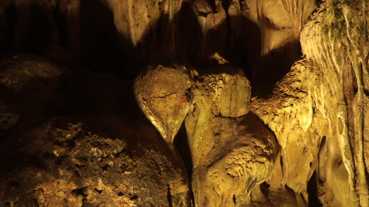 Natural rock formations inside a dimly lit cave in Halong Bay Vietnam with textured surfaces