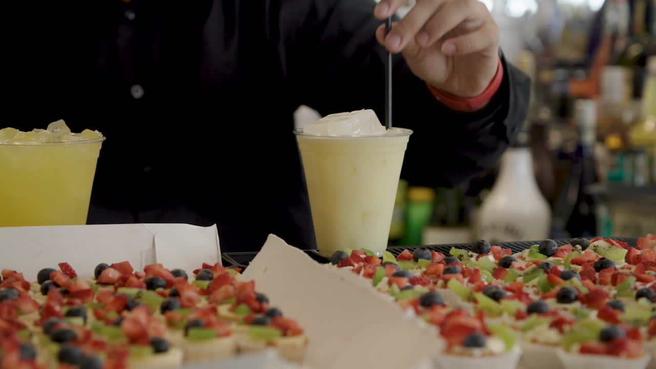 preparing yellow mixed drinks at a bar