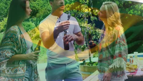animation of brazil flag waving over diverse friends drinking beverage and standing beside barbeque