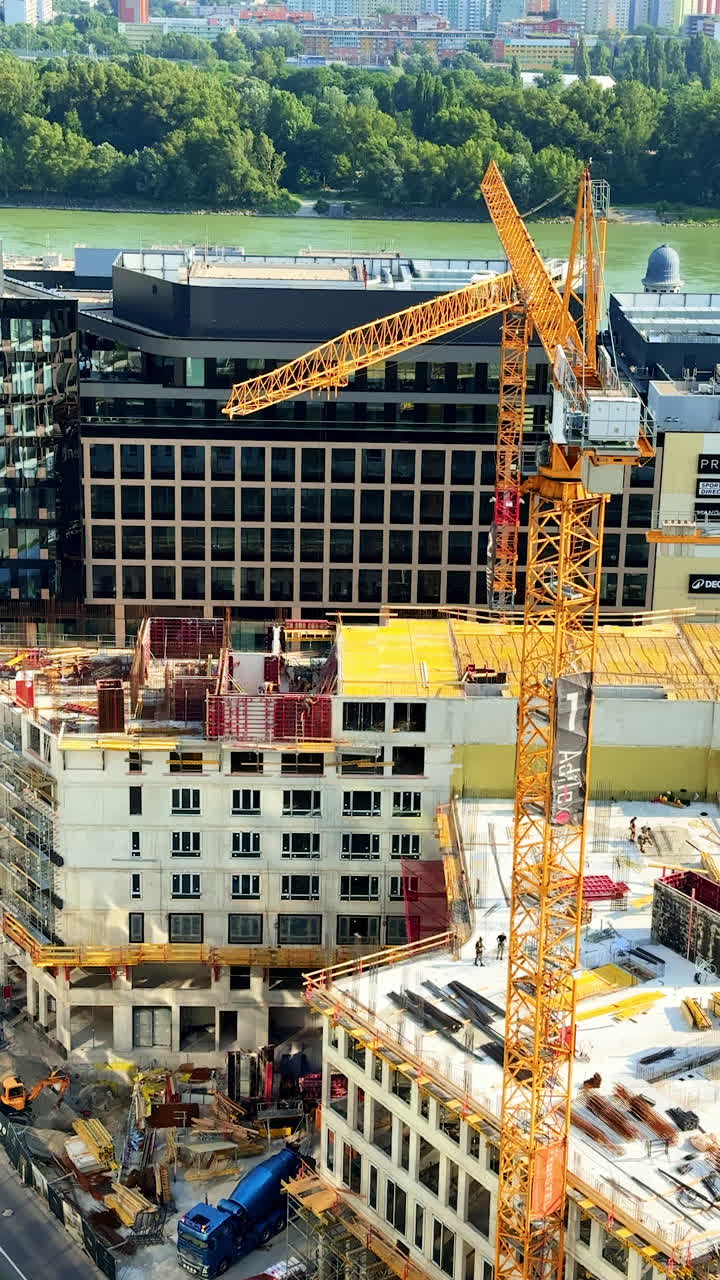 Urban construction site with crane. A busy urban construction site has a tower crane and active building work during the day