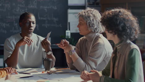 diverse students and english teacher using flashcards during discussion