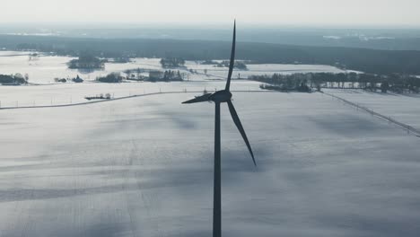 close-up in slow motion of a wind turbine against the snowy backdrop of the baltic countryside