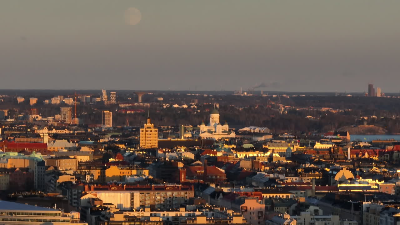 telefoto tomada por un dron alrededor del horizonte de helsinki, puesta de sol de luna llena en finlandia