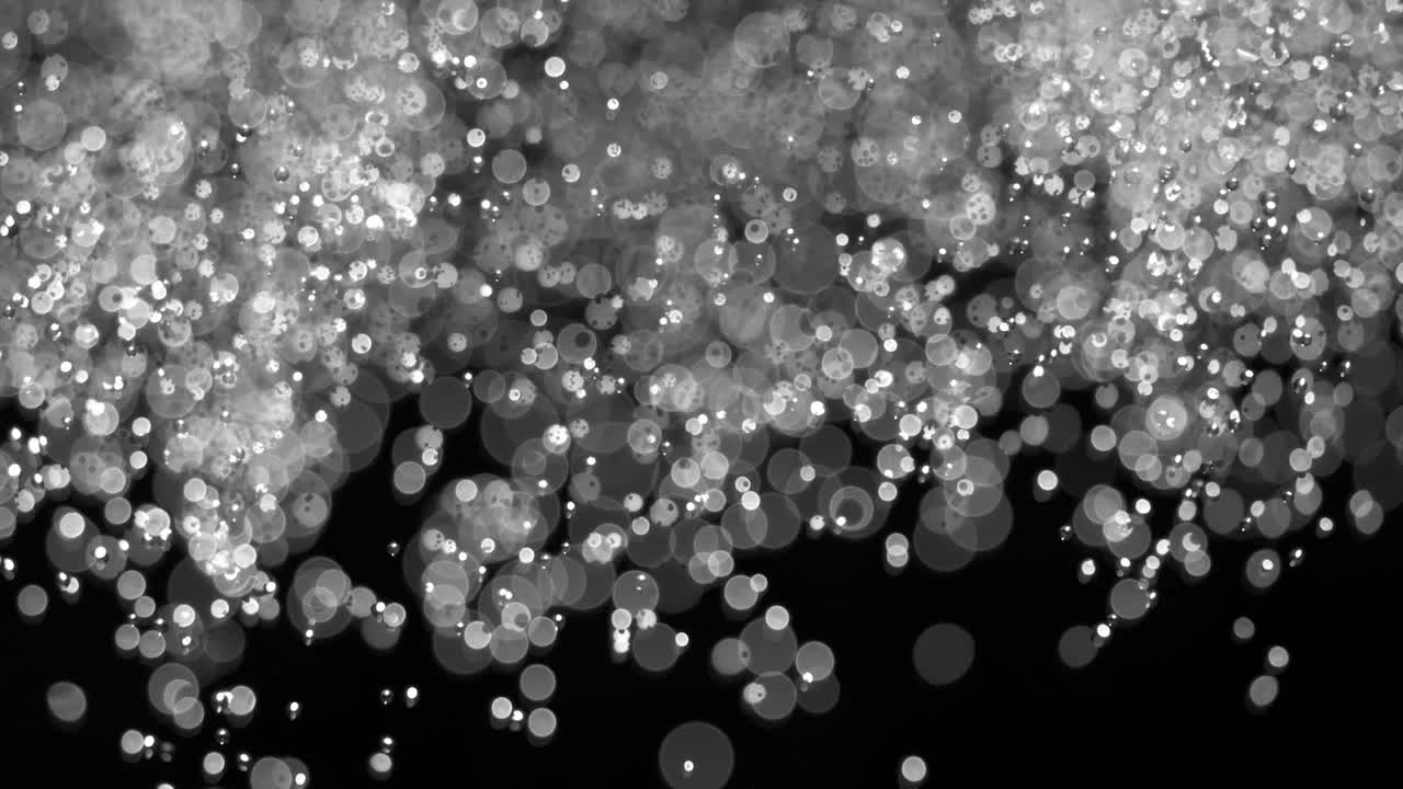Floating abstract particle bokeh on dark background. Shot on super slow motion camera 1000 fps.