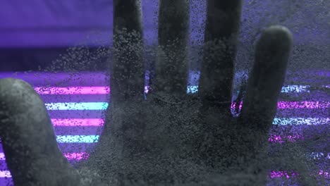 abstract hand with dust particles and neon light