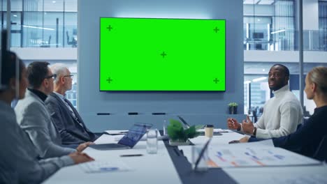 office conference room meeting using green screen chroma key tv: multi-ethnic group of top managers, executives talk. businesspeople work on an e-commerce strategy. medium wide static