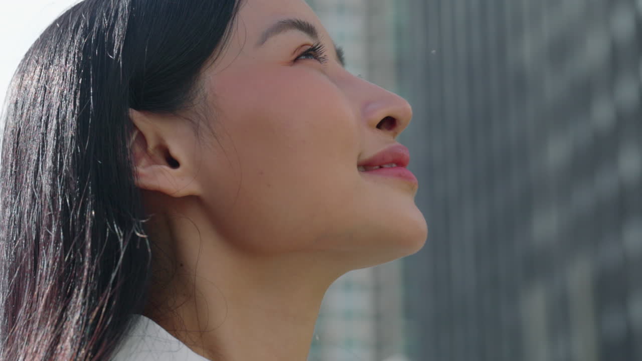 Close-up of an Asian woman looking up with a thoughtful expression