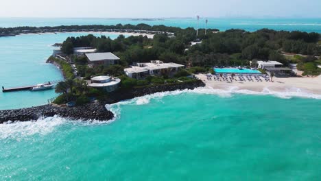 Aerial-drone-footage-of-Nurai-Island-showcasing-the-beauty-of-its-sandy-coastline,-clear-turquoise-waters,-and-opulent-retreats