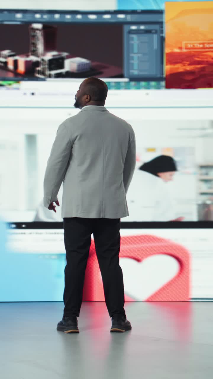 Vertical video Man surrounded by streaming videos on digital videowall