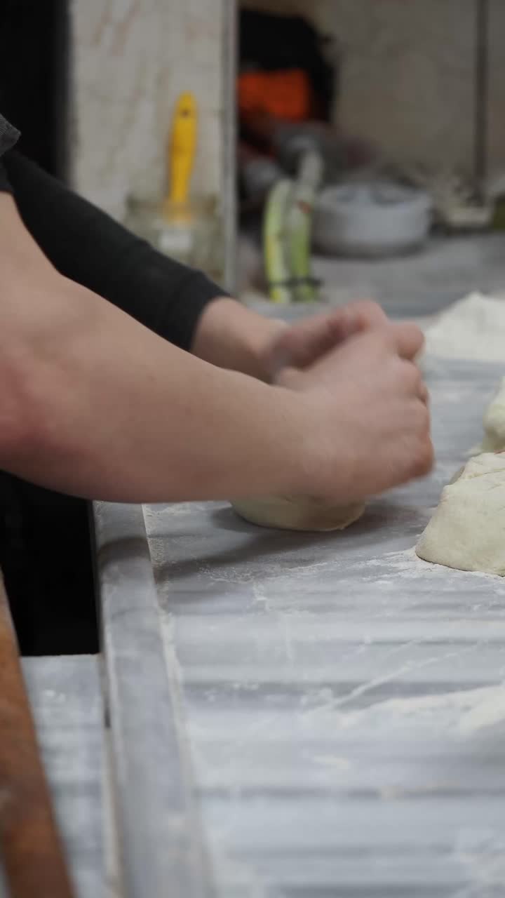 Hands Kneading Fresh Dough on a Floured Marble Counter