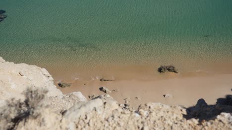 Moving-down-shot,-Scenic-view-of-Crystal-clear-Coastline-in-Algarve,-Portugal,-Bright-Sunny-day-in-the-background