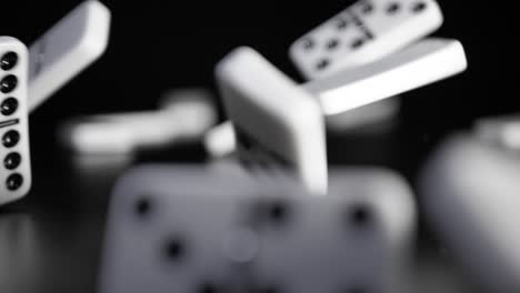 white domino dice fall on a black background