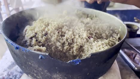 hand of woman cooking moro de guandules typical food in dominican republic