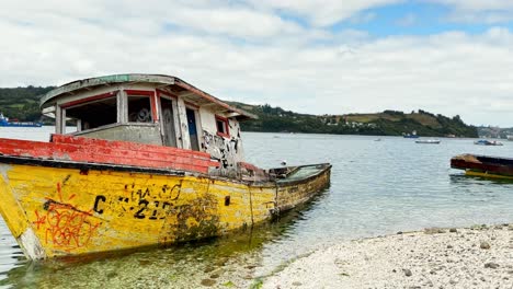 barco típico abandonado amarrado en la costa de dalcahue, tiro de pan