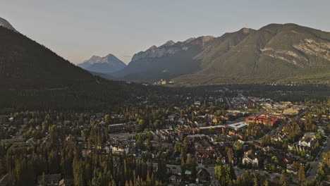 Banff-Ab-Canada-Aérea-V21-Zona-Residencial-De-Paso-Elevado-Y-Municipio-De-Montaña-Que-Captura-Un-Paisaje-Urbano-Pintoresco,-Un-Valle-Boscoso-Y-Un-Paisaje-Montañoso-Al-Amanecer---Filmado-Con-Mavic-3-Pro-Cine---Julio-De-2023