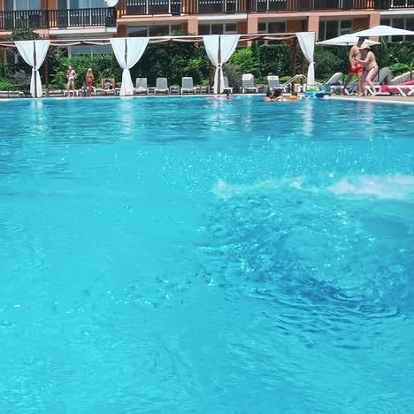 man jumping in swimming pool at sunny day.