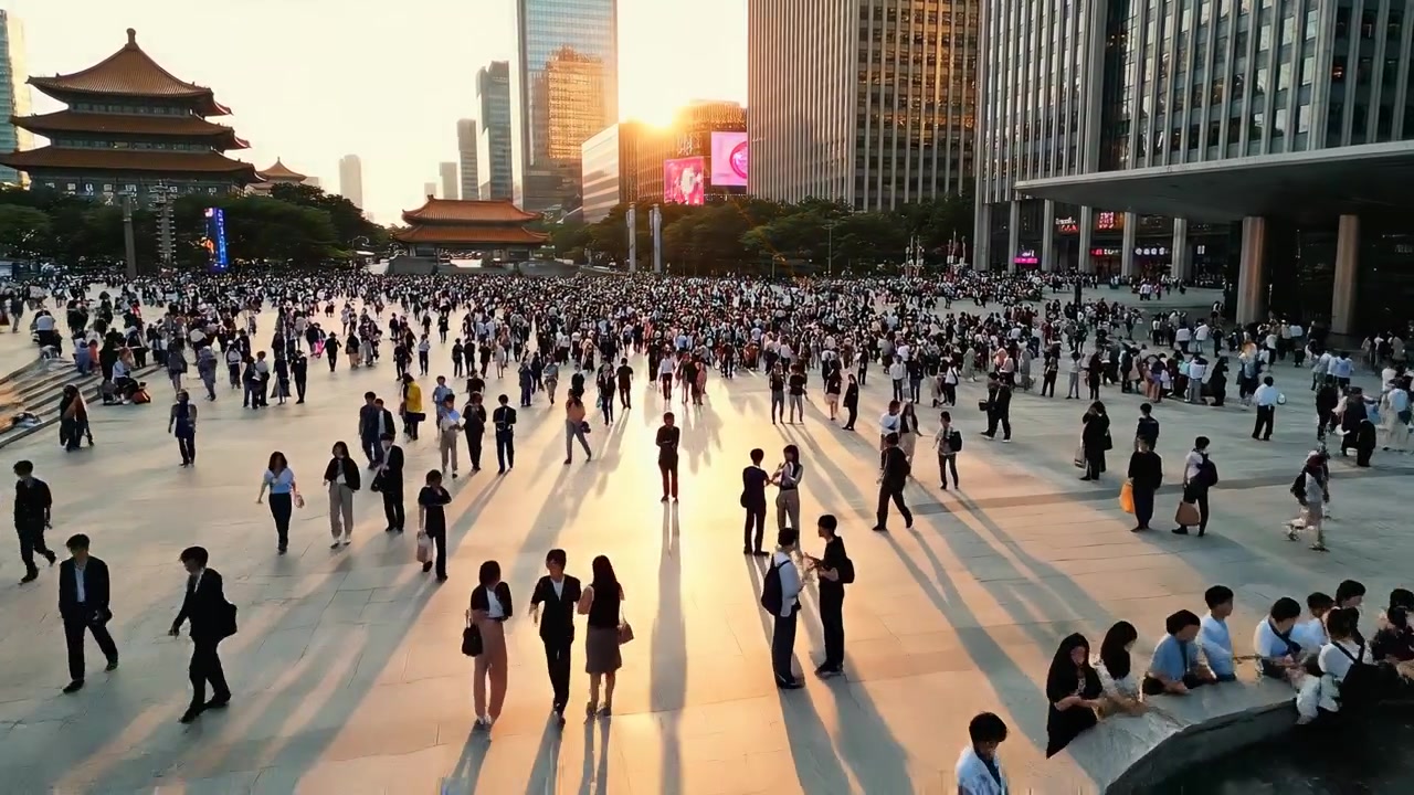 夕暮れの都市広場を歩く大勢の人々
