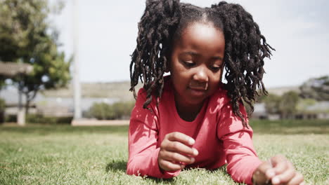 young girl lying on grass, exploring nature with curiosity and joy