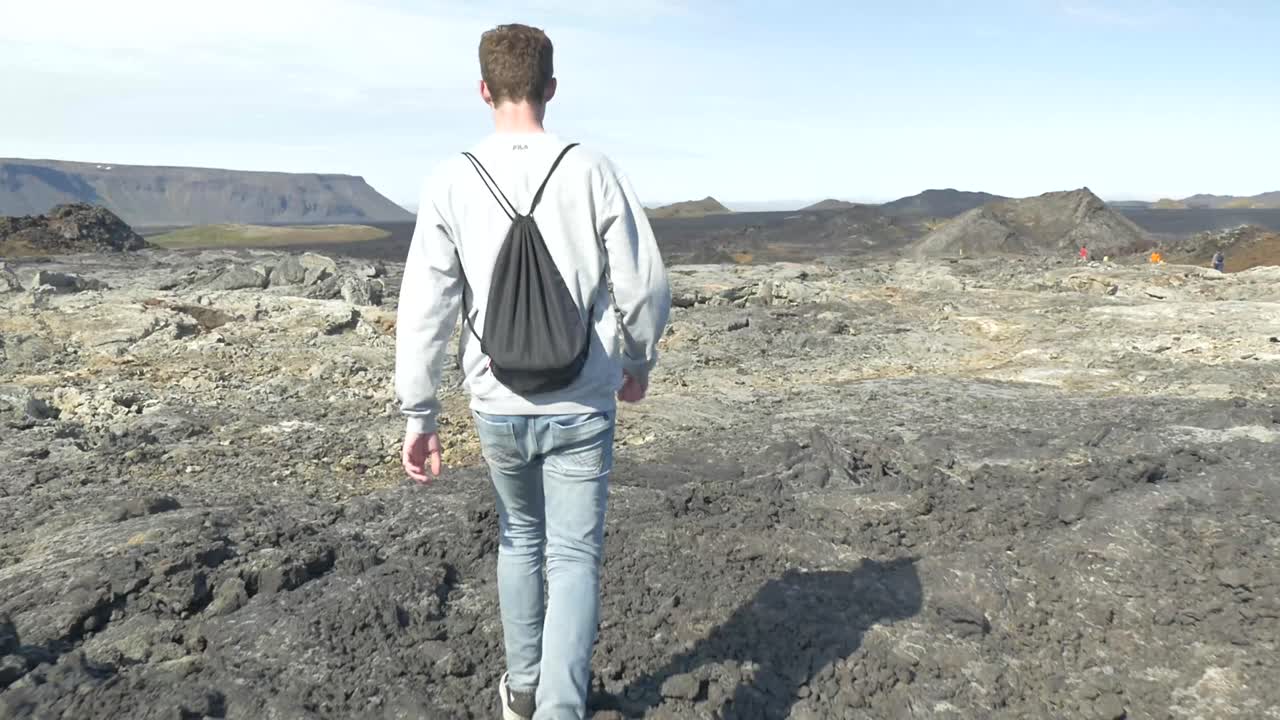 Persona che cammina nel paesaggio vulcanico in Islanda-1