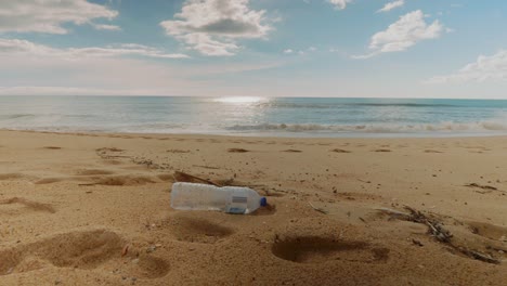 plastic bottle on the beach, slow rolling waves in the distance