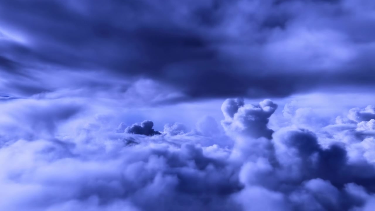 Elevated view over dense cloud field with billowing cumulus tops rising beneath broad stratocumulus ceiling, soft blue light, layered texture, and strong atmospheric depth across wide horizon