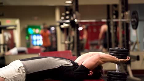 closeup side shot of bodybuilder adjusting himself to do lying triceps pullover or presses