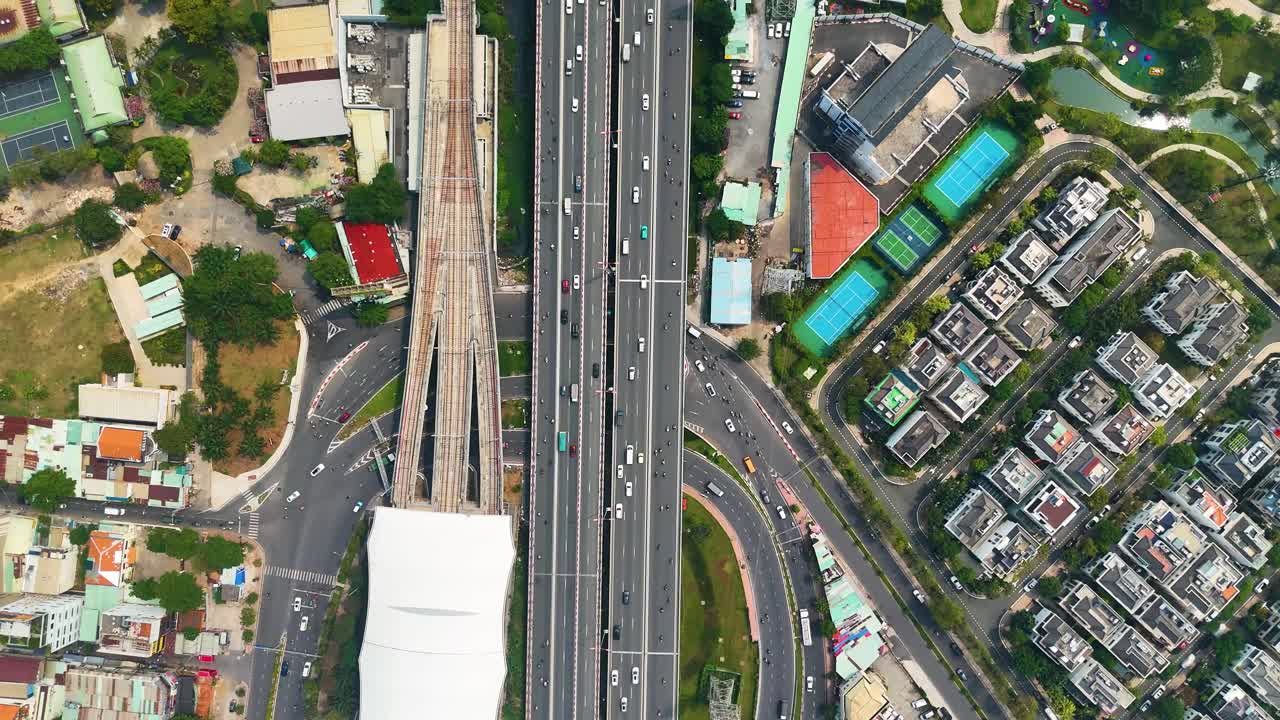 Aerial: metro station and traffic on roads during the day in Ho Chi Minh City, Vietnam, top-down drone shot
