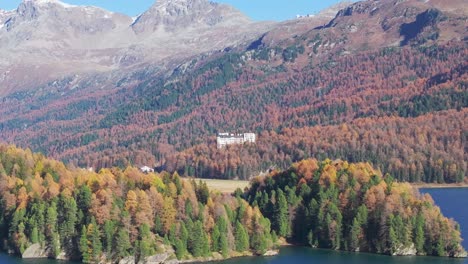 aerial drone shot grand hotel stands in the autumn fir forest in the mountains