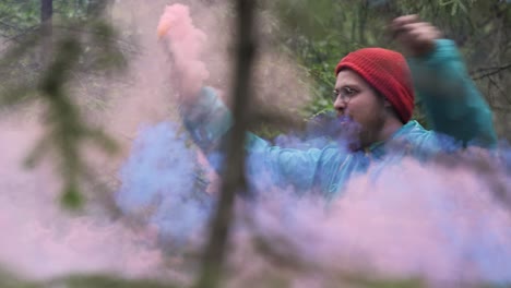 man in a forest with pink smoke