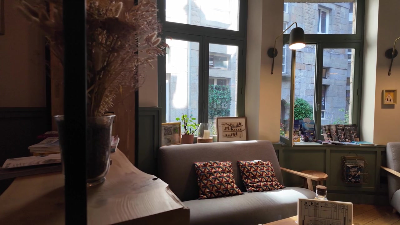Video al rallentatore di un accogliente interno di caffetteria a Saint-Malo, caratterizzato da illuminazione calda, sedute confortevoli e un'atmosfera accogliente all'interno di un affascinante caffè francese.