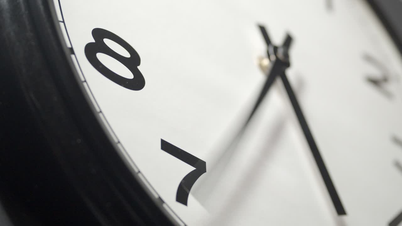 White Clock Face Close Up in Time Lapse on Dark Grey Wall