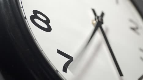 white clock face close up in time lapse on dark grey wall