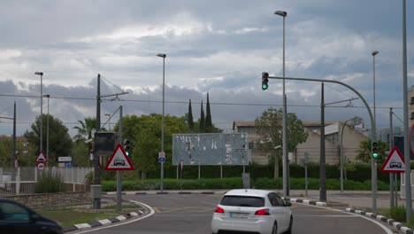 cars driving through a city intersection on a cloudy day