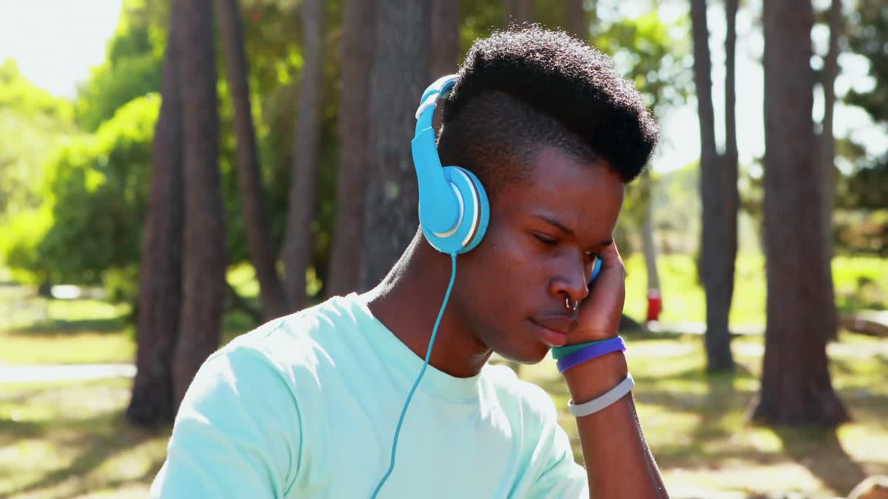 hombre con auriculares montando en bicicleta en el parque 4k