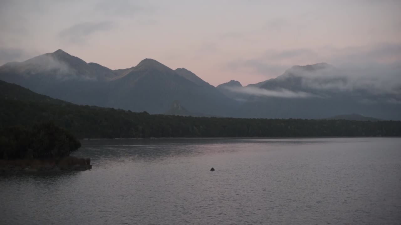 Warm light of the sunrise over Lake Manapouri. Mountain and lake scenery of New Zealand south island