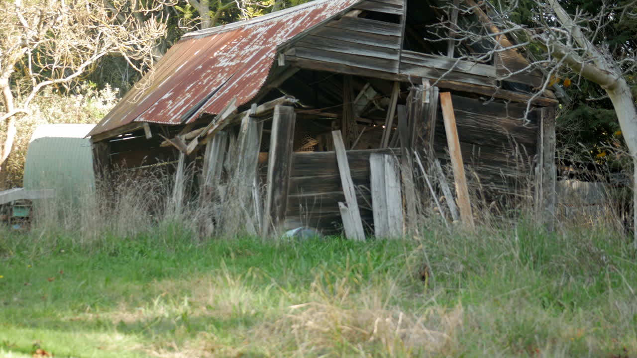 antiguo cobertizo de madera descuidado con techo de hierro oxidado