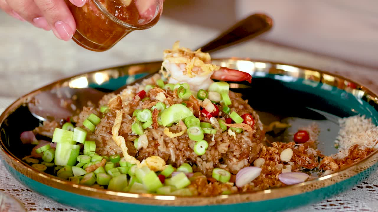 vertiendo salsa sobre pasta de camarón y arroz frito