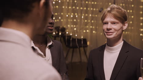 Close-Up-View-Of-Group-Friends-Wearing-Stylish-Clothes-While-Talking-And-Holding-Champagne-Glasses-At-New-Year's-Party-1