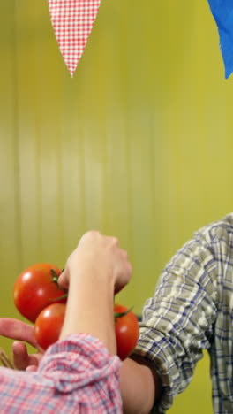 mujer comprando tomates al personal masculino