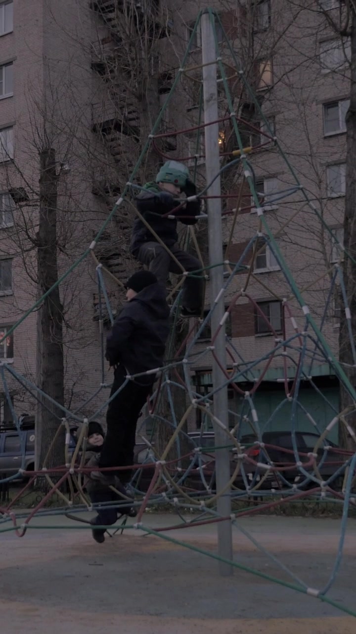 Children having fun with rope web climber on playground