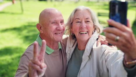 Peace-sign,-selfie-and-senior-couple-kiss-at-park