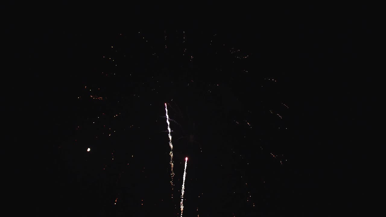 Fuochi d'artificio colorati esplodono in modo spettacolare nel cielo notturno, creando uno spettacolo vivace. Lo spettacolo presenta varie forme e colori, che catturano gli spettatori a ogni esplosione.