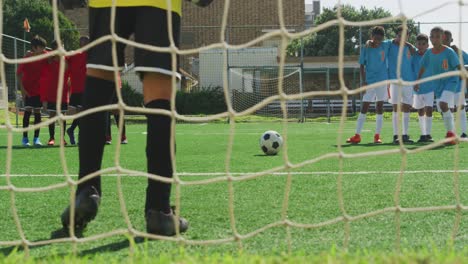 african american kid in blue scoring in a sunny day