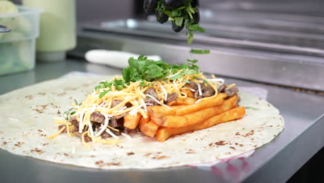 making a california burrito with fries, meat, cheese, cilantro - food truck series